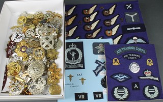 A quantity of Second World War and later cap badges and cloth badges