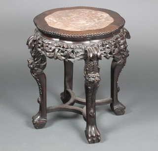 A 19th Century circular Chinese pierced and carved hardwood jardiniere stand with pink veined marble top, raised on cabriole supports united by a stretcher 23" x 18" diam. 