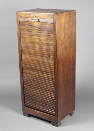 An Art Deco oak filing cabinet, the interior fitted 9 trays enclosed by a tambour shutting 45"h x 18 1/2"w x 14"d 