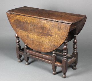 An 18th Century oak gateleg drop flap dining table, fitted a drawer and raised on turned supports 28"h x 39"w x 13" when closed by 47" when open 