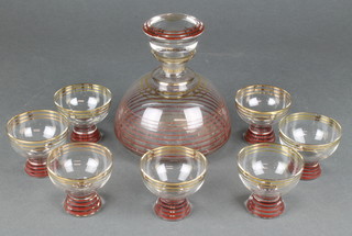 An Art Deco gilt and red banded cocktail set comprising a decanter and 7 tots 