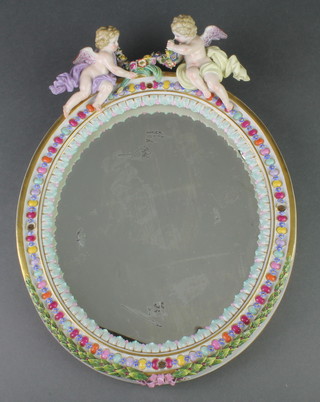 A modern Meissen oval mirror surmounted by cherubs and decorated with leaves and berries 12" 