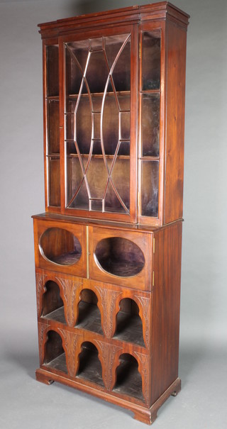 A 19th Century mahogany breakfront bookcase on cabinet with moulded cornice, fitted adjustable shelves enclosed by astragal glazed panelled doors, the base fitted a cupboard enclosed by oval glazed panelled doors above a recess 73 1/2"h x 27"w x 13"d 