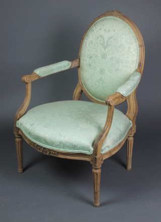A Continental oak show frame salon chair upholstered in green material, raised on turned and fluted supports 