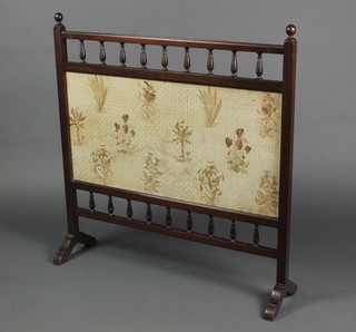 An Edwardian rectangular mahogany fire screen with stitchwork panel to the centre and bobbin turned decoration, 33"h x 32"w 