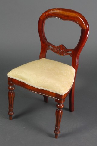 A childs Victorian style mahogany balloon back chair, raised on turned and reeded supports 