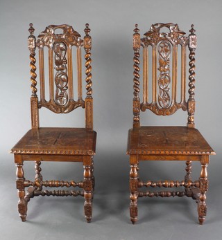 A pair of Victorian carved light oak Carolean style hall chairs with pierced backs and solid seats, raised on spiral turned supports 