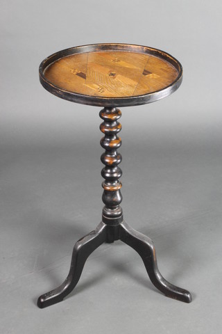 A circular wine table, the oak dish top with marquetry inlay, raised on an ebonised bobbin turned column and tripod base 27 1/2"h x 15"d 