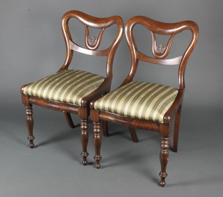 A pair of Victorian buckle back dining chairs with upholstered drop in seats, raised on turned supports 