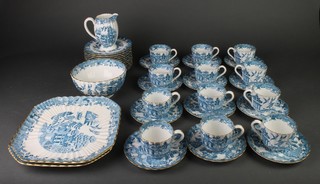 A Spode Willow pattern part tea set comprising 12 cups, 12 saucers, 2 cake plates, cream jug, sugar bowl and 12 side plates