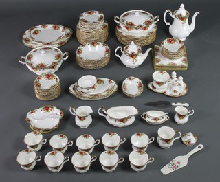 A Royal Albert Old Country Roses tea and dinner service comprising 2 tureens and covers, 10 dinner plates, 15 side plates, 13 small plates, 9 soup bowls, 6 serving dishes, a gravy boat, teapot, coffee pot, cream jug, milk jug, 11 tea cups, 21 saucers, 3 small dishes, sugar bowl, 2 handled dish, squat bowl, hors d'oeuvres dish, teacup and stand, 2 condiments, a bell, cake slice, table mats, stand, 