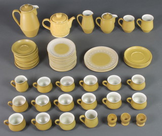 A 1970's Denby tan glazed tea and coffee set comprising 14 tea cups, 3 mugs, a teapot, coffee pot, milk jug, similar teapot, 18 saucers, 14 side plates, 3 large plates and 3 egg cups