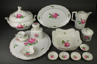 An extensive 20th Century Meissen rose decorated coffee and dinner service comprising 6 coffee cups, 6 saucers, a coffee pot, milk jug, tea caddy, 5 tea cups, 4 two handled bowls, a lidded sugar bowl, a square kettle stand, 24 dinner plates, 8 side plates, 10 soup bowls, 11 side plates, a salad bowl, 2 serving dishes, a rectangular dish, a candlestick, 2 leaf shaped dishes, a sauce boat, 3 lidded tureens, 3 oval meat plates, 2 large dishes, a cake stand, 8 bowls and 5 small dishes 
