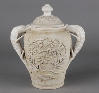 A 19th Century cream glazed oviform 2 handled vase and cover with scrolling floral decoration and stylised dragon handles 7" 