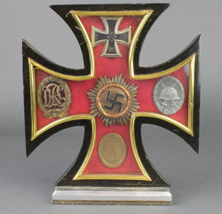 A facsimile Iron Cross First Class together with 4 other German facsimile decorations, contained in an ebonised wooden frame 