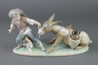 A Lladro figure of a young boy pulling a donkey with a dog at his feet H17/M 11 1/2" 