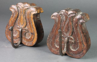 A pair of carved oak and iron tulip shaped curtain tie backs 5"