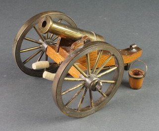 A model of a brass cannon with 4 1/2" barrel, raised on an oak carriage