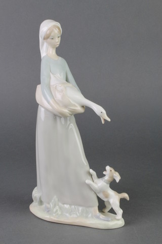 A Lladro figure of a goose girl with a puppy at her feet 11" 