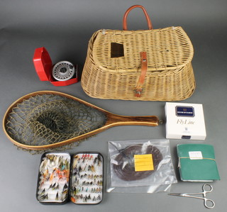 A Treenslope wooden landing net, a box of flies, a Leeda Rimfly fly reel and a Hardys fly line, all contained in a creel basket 