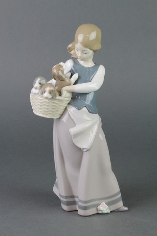 A Lladro figure of a young lady holding a basket of puppies 10" 