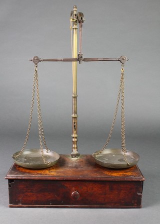 A pair of 19th Century brass scales raised on a mahogany base fitted a drawer 