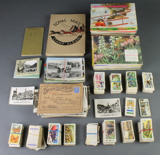 A Royal Mail album of used world stamps, various tea cards, cigarette cards and a small collection of postcards 