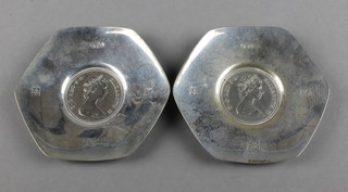 A pair of hexagonal silver coin set dishes, Birmingham 1974 