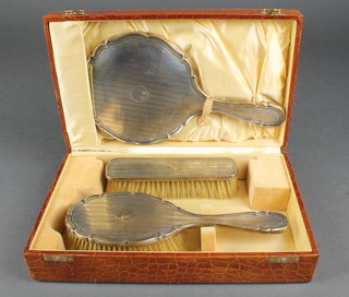 A cased 3 piece silver brush set with engine turned decoration, Birmingham 1923 