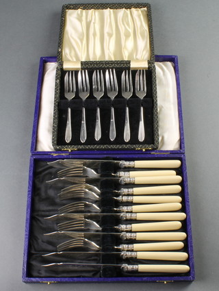 A cased set of silver plated cake forks and a ditto of fish eaters