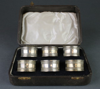 A set of 6 cased engine turned silver napkin rings, Sheffield 1938, 84 grams 
