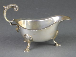 A silver sauce boat with cut rim and fancy S scroll handle with shell knees and feet, London 1941, 186 grams