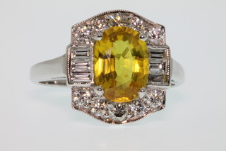 An 18ct yellow sapphire and diamond cluster ring, the centre stone approx. 2.65ct surrounded by 8 brilliant and 6 baguette cut diamonds approx 0.8ct, size L 1/2