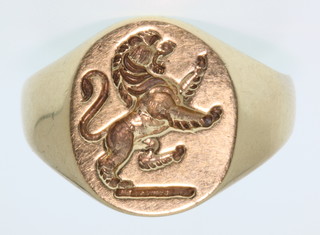 A gentleman's 9ct gold die cut signet ring with lion armorial, size T, 6 grams