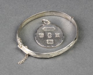 A silver bangle and pendant, 36 grams