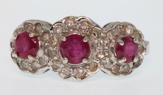 An 18ct white gold ruby and diamond triple cluster ring, size L 