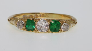 An 18ct gold diamond 3 and emerald 2 stone diamond ring, size J