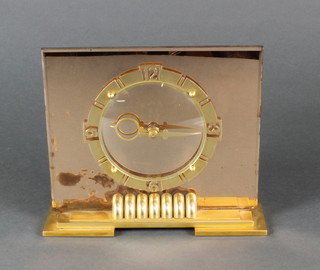 An Art Deco Time Master electric clock contained in an amber tinted case