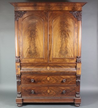 A Victorian mahogany linen press with moulded cornice, fitted 2 shelves enclosed by arched panelled doors, the base fitted a secret drawer above 2 long drawers with vitruvian scrolls to the sides, tore handles 88"h x 62 1/2w x 27"d 