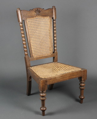 An 18th/19th Century fruitwood chair of joyned construction with woven cane seat and back and bobbin turned columns to the sides 