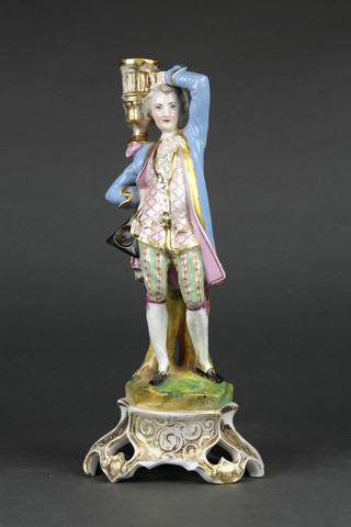A late 19th Century Continental candlestick in the form of a gentleman holding a sconce on a raised rococo base 15" 