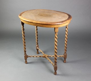 An oval walnut occasional table with cane top, raised on spiral turned supports with X framed stretcher 27"h x 25"w x 18 1/2"d 