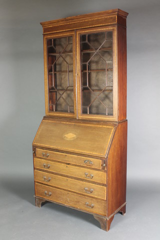 An Edwardian inlaid mahogany bureau bookcase, the upper section with moulded cornice, fitted adjustable shelves enclosed by astragal glazed panelled doors, the fall front revealing a fitted interior above 4 long graduated drawers, raised on bracket feet 78"h x 36"w x 16"d 