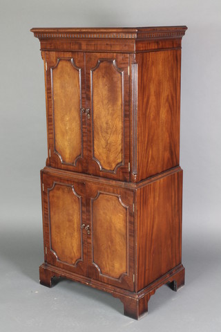 A Georgian style cabinet with moulded and dentil cornice, hinged lid, the upper section fitted shelves enclosed by a pair of panelled doors, the base fitted a drawer enclosed by panelled doors, raised on bracket feet 53"h x 25"w x 17"d , the reverse with Harrods label 