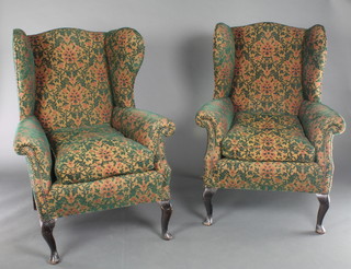 A pair of Georgian style winged armchairs upholstered in green and red floral material 