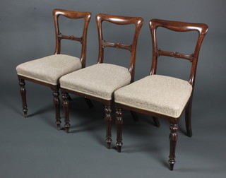 3 Victorian mahogany buckle back dining chairs with carved mid rails and upholstered seats, on turned and reeded supports 