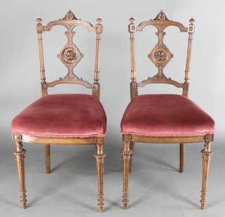 A pair of Victorian walnut bedroom chairs with shaped cresting rails and splat backs, upholstered seats, raised on turned and reeded supports 