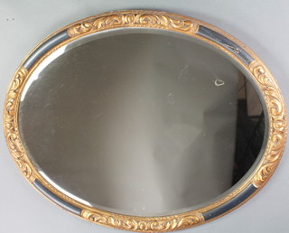 An oval bevelled plate wall mirror contained in a decorative gilt and black carved frame 27", together with a similar pair of circular mirrors 10" 