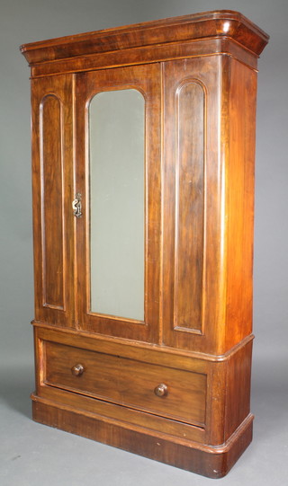 A Victorian mahogany D shaped wardrobe with moulded cornice, the interior enclosed by an arch panelled mirrored door, the base fitted a drawer with tore handles, raised on a platform base 80"h x 48"w x 18"d 