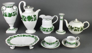 A 20th Century vinous decorated Meissen tea, coffee, dinner and table service comprising a bulbous teapot, 2 coffee pots, a milk jug, a cake stand, 6 small side plates, 10 tea cups, a lidded sugar bowl, a slop bowl, a teapot stand, a chamber stick, an oval dish, a tapered vase, 2 twin handled vases, 6 medium size plates, 21 saucers, a cream jug, a preserve pot and lid, 10 coffee pots, 2 chocolate pots, a candlestick, 10 side plates and 2 cake dishes